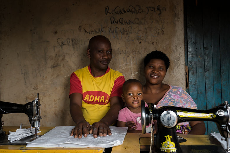 A man, woman, and child sitting with sewing machines