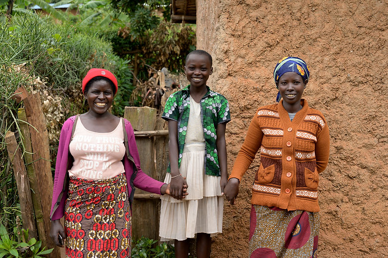 Young girl in middle holding hands with two women