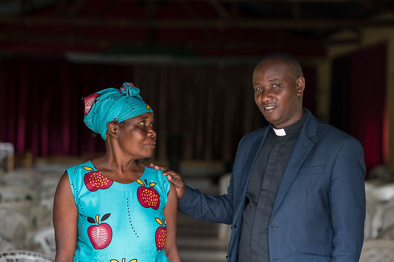 A woman and her priest standing in the doorway of a church
